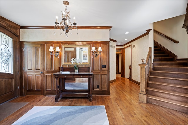 foyer featuring ornamental molding, a chandelier, and hardwood / wood-style floors