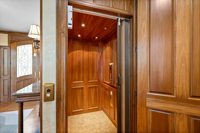 details featuring wood walls and elevator