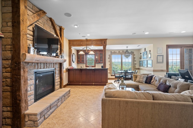 tiled living room with a notable chandelier and a fireplace