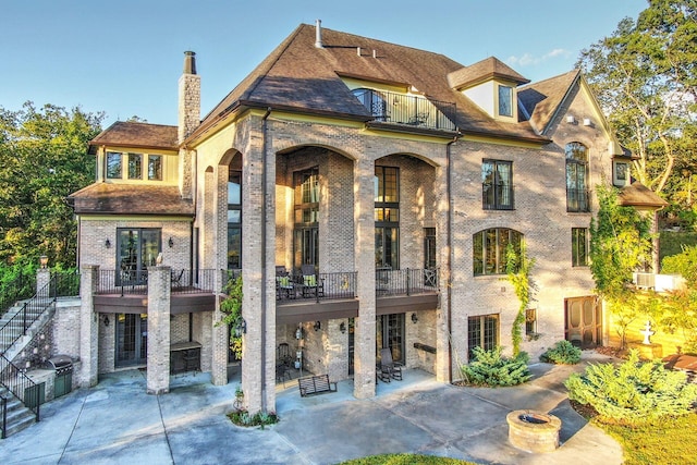 rear view of property with a balcony and a patio