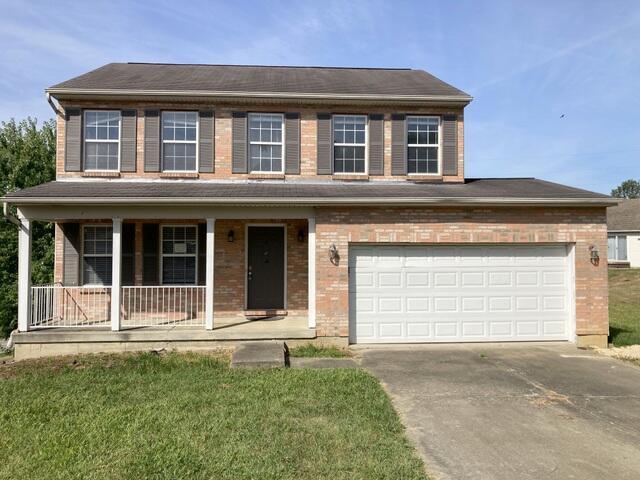 view of front facade with a porch, a garage, and a front yard