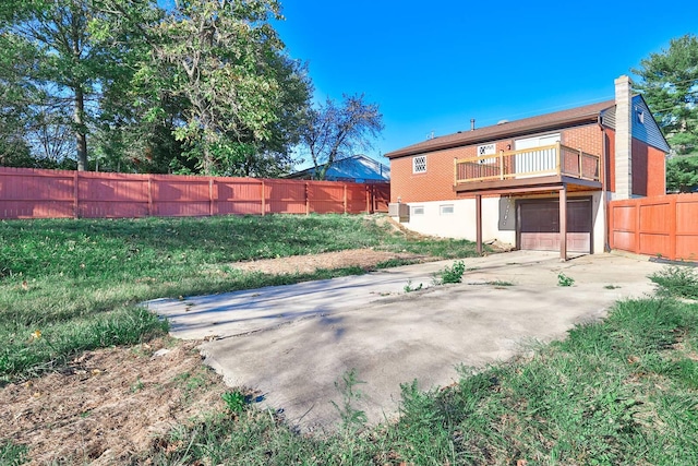 rear view of property with a balcony and a garage