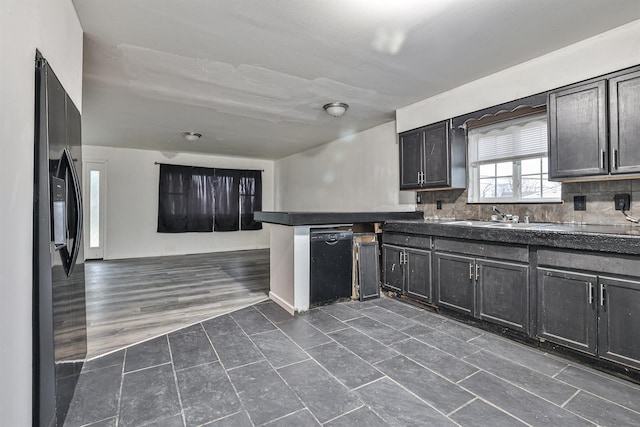 kitchen with backsplash, black appliances, sink, dark hardwood / wood-style flooring, and kitchen peninsula