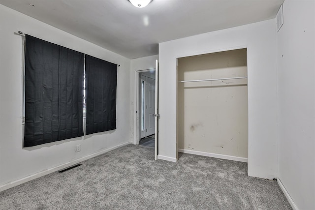 unfurnished bedroom with light colored carpet and a closet