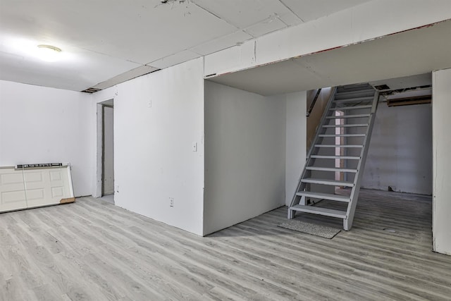 basement with light hardwood / wood-style flooring