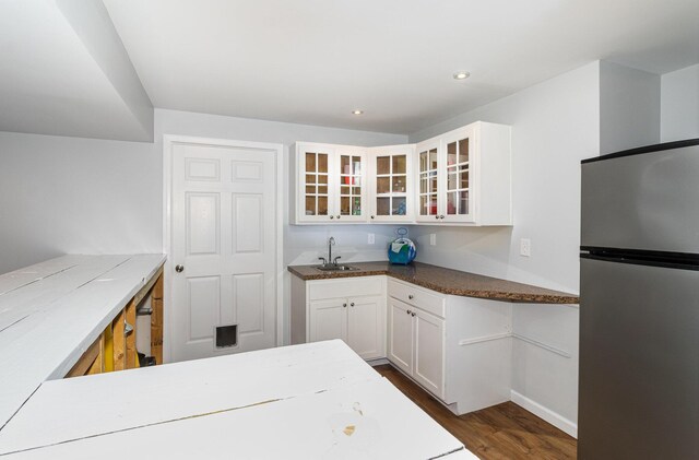 kitchen featuring sink, white cabinetry, dark wood-type flooring, and stainless steel refrigerator