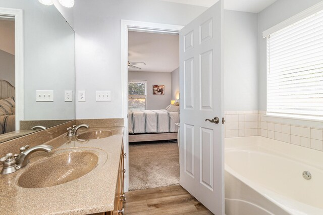 bathroom featuring ceiling fan, a bathtub, vanity, and hardwood / wood-style flooring