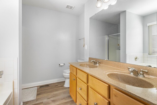 full bathroom featuring vanity, toilet, wood-type flooring, and shower with separate bathtub