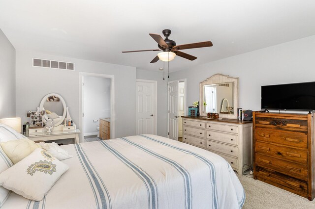 bedroom with ensuite bathroom, ceiling fan, and light carpet