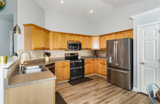 kitchen featuring backsplash, high vaulted ceiling, sink, light hardwood / wood-style flooring, and stainless steel appliances