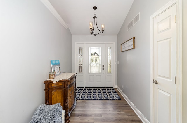 foyer entrance featuring dark hardwood / wood-style flooring, a chandelier, and lofted ceiling