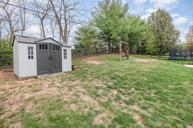 view of yard featuring a storage unit and a trampoline