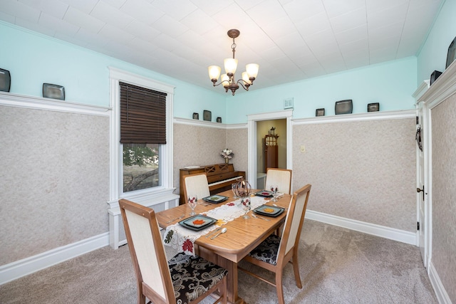 dining space with baseboards, carpet floors, a notable chandelier, and wallpapered walls