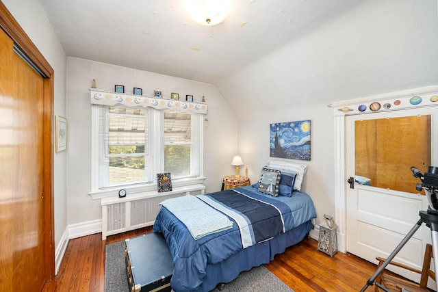 bedroom featuring vaulted ceiling, radiator heating unit, baseboards, and wood finished floors