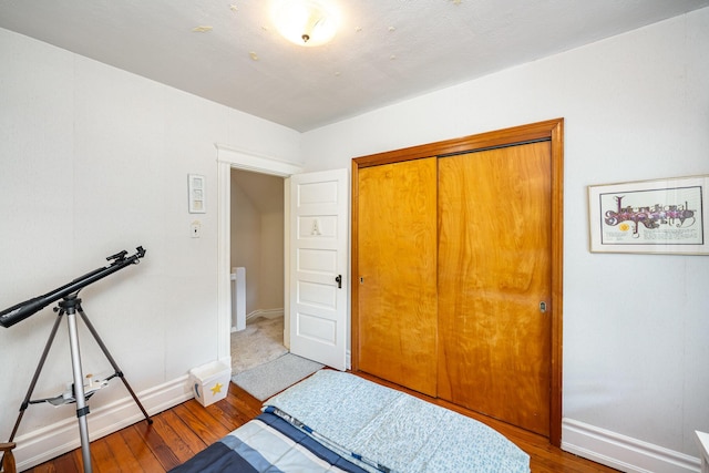 bedroom featuring a closet, baseboards, and wood finished floors