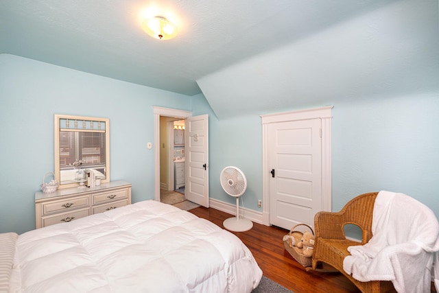 bedroom with lofted ceiling, wood finished floors, and baseboards