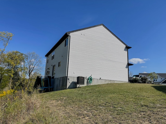 view of side of home with a yard and central air condition unit