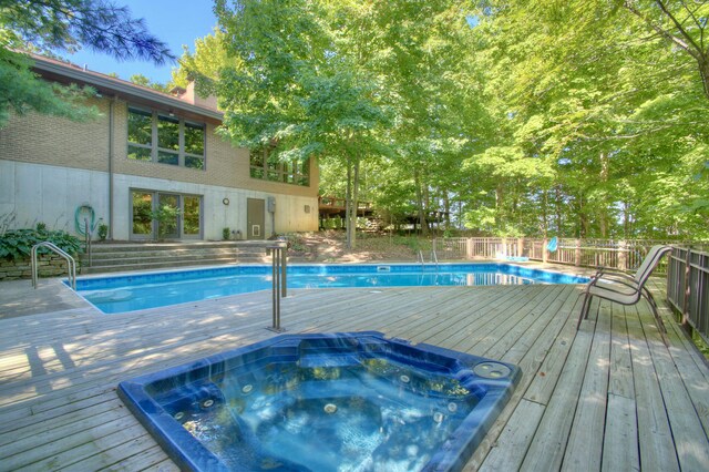 view of pool with an outdoor hot tub and a deck