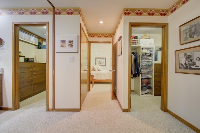 hallway featuring light colored carpet