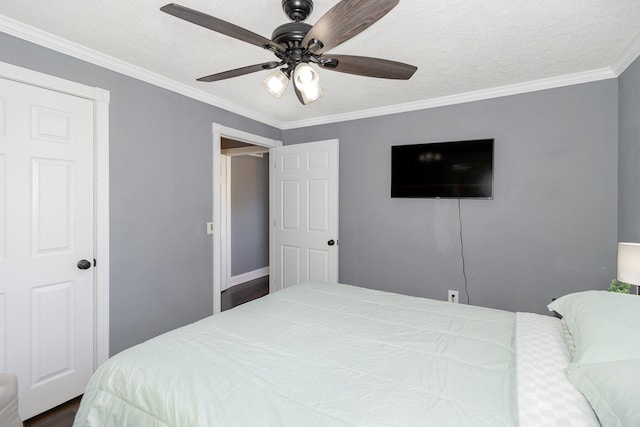 bedroom featuring ceiling fan, ornamental molding, dark hardwood / wood-style flooring, and a textured ceiling