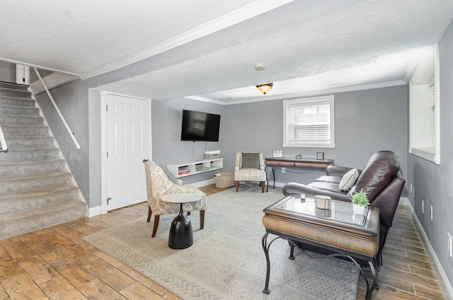 living room with a textured ceiling, ornamental molding, and hardwood / wood-style floors