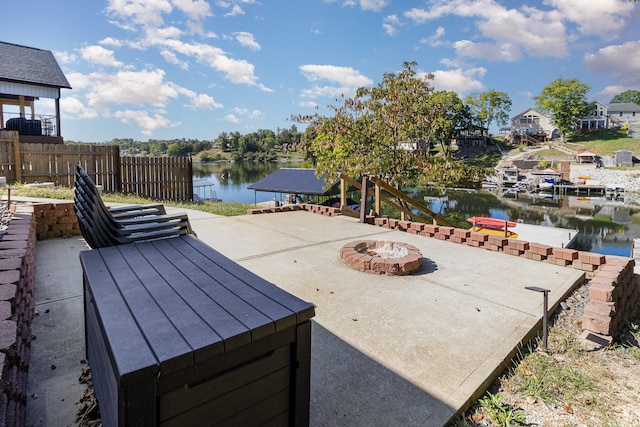 exterior space with an outdoor fire pit, a water view, and a patio