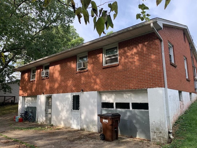 rear view of house with a garage and cooling unit