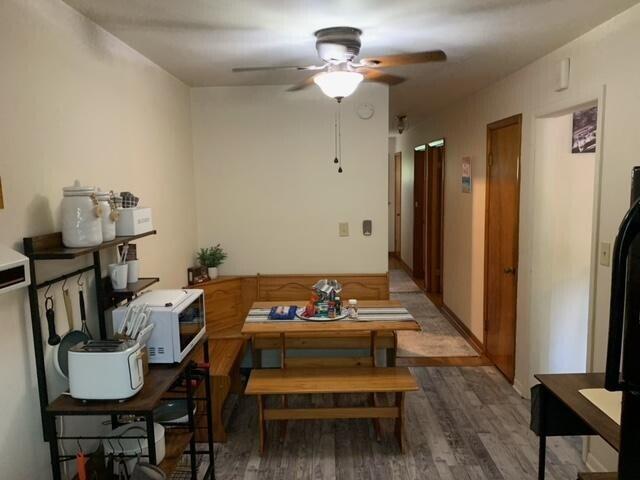 dining area with wood-type flooring and ceiling fan