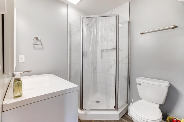 bathroom featuring vanity, toilet, hardwood / wood-style flooring, and a shower with shower door