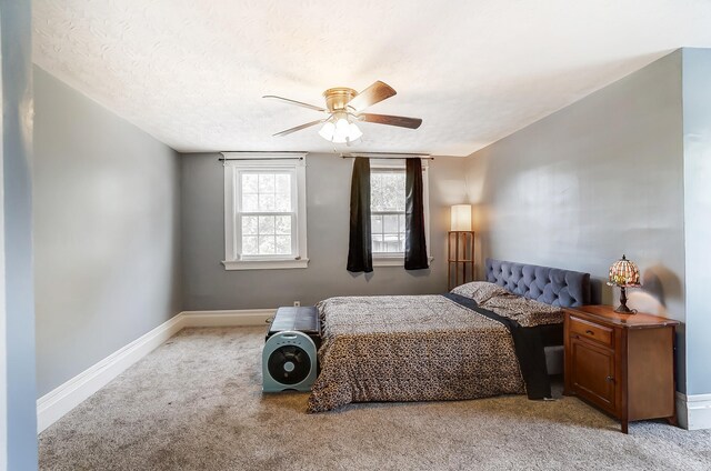 carpeted bedroom featuring a textured ceiling and ceiling fan