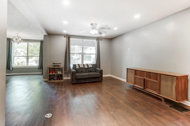 unfurnished room featuring dark wood-type flooring and ceiling fan with notable chandelier