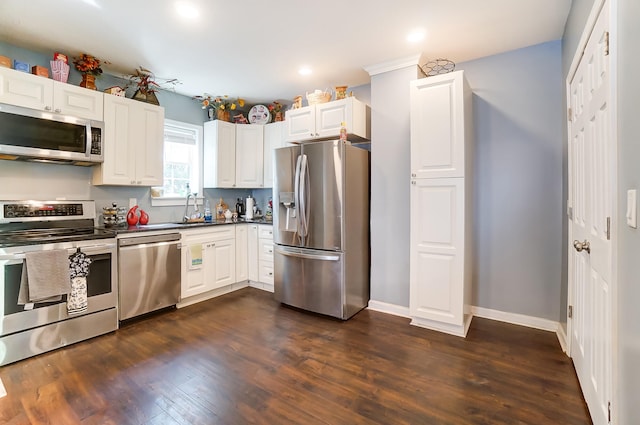 kitchen featuring dark hardwood / wood-style flooring, sink, stainless steel appliances, and white cabinets