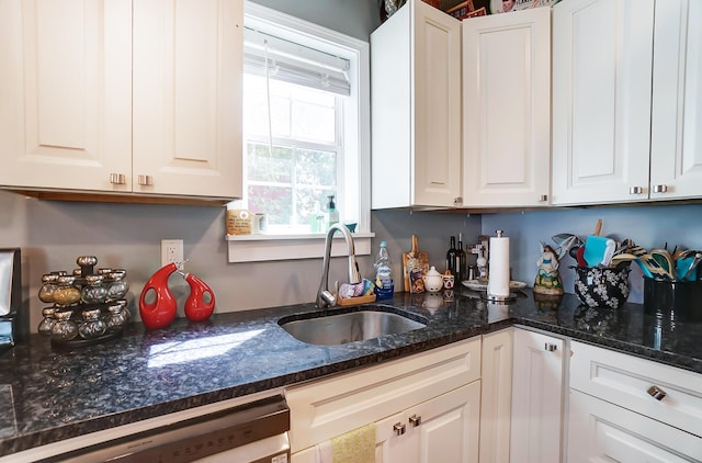 kitchen with dishwasher, white cabinetry, and sink