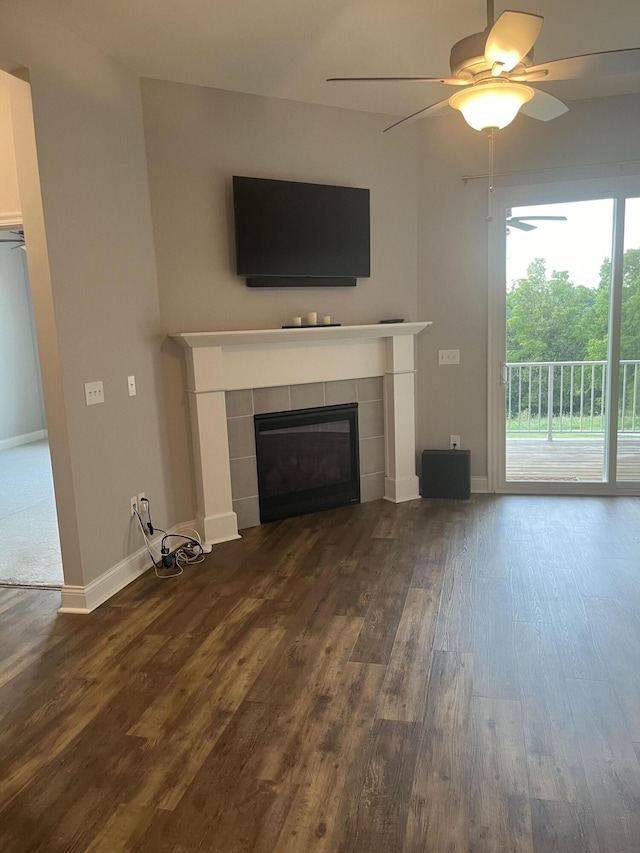 unfurnished living room with dark wood-type flooring, ceiling fan, and a tile fireplace