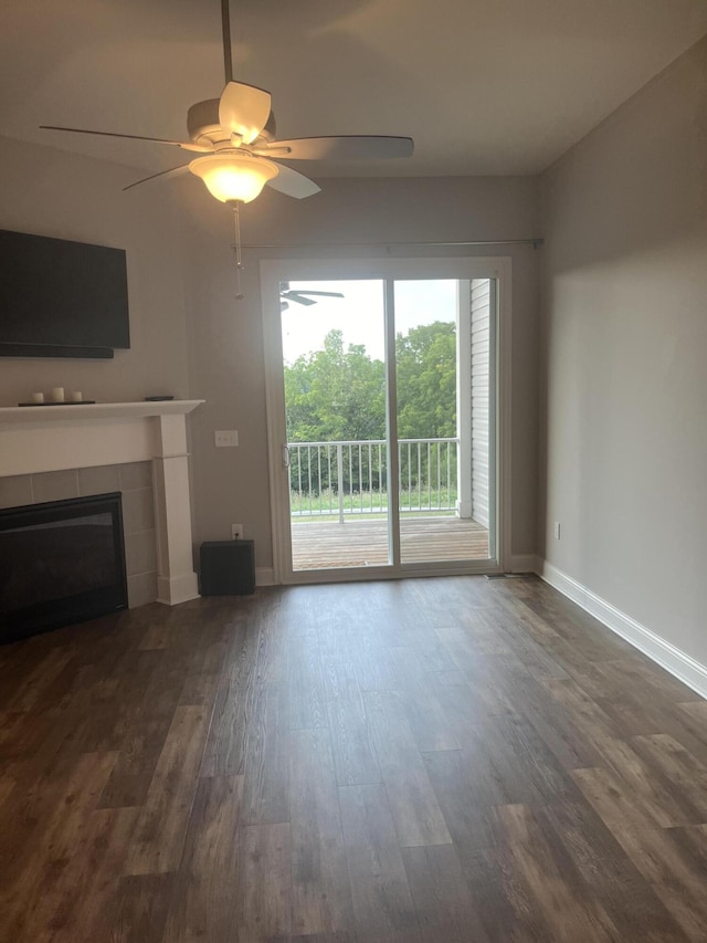 unfurnished living room with a fireplace, ceiling fan, and dark hardwood / wood-style floors