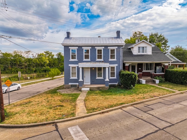 view of front facade featuring covered porch and a front yard