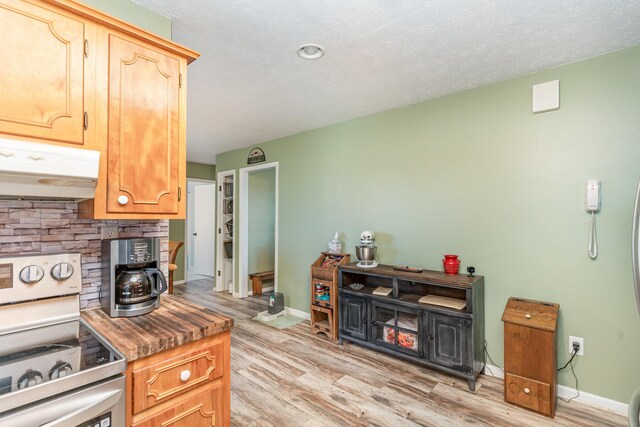 kitchen featuring a textured ceiling, electric range, and light hardwood / wood-style floors