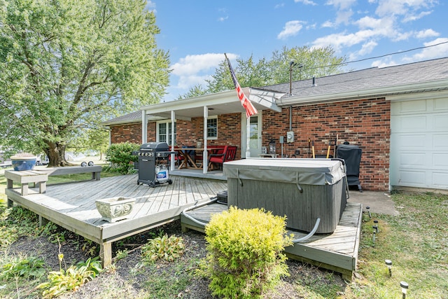 deck featuring a grill, a garage, and a hot tub