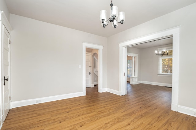 unfurnished dining area featuring wood-type flooring and a chandelier