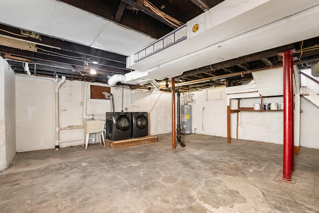 basement featuring separate washer and dryer, sink, and water heater