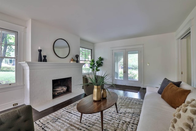 living room featuring a fireplace, french doors, plenty of natural light, and dark hardwood / wood-style floors