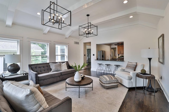 living room with hardwood / wood-style floors, crown molding, sink, a chandelier, and lofted ceiling with beams