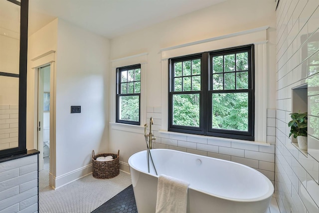 bathroom with tile walls, tile patterned flooring, and a washtub