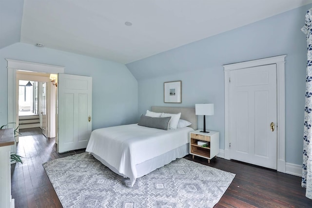 bedroom with vaulted ceiling and dark hardwood / wood-style flooring