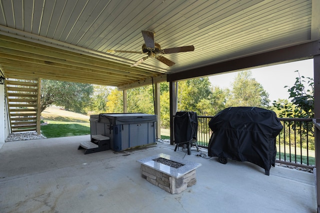 view of patio with ceiling fan, an outdoor fire pit, grilling area, and a hot tub