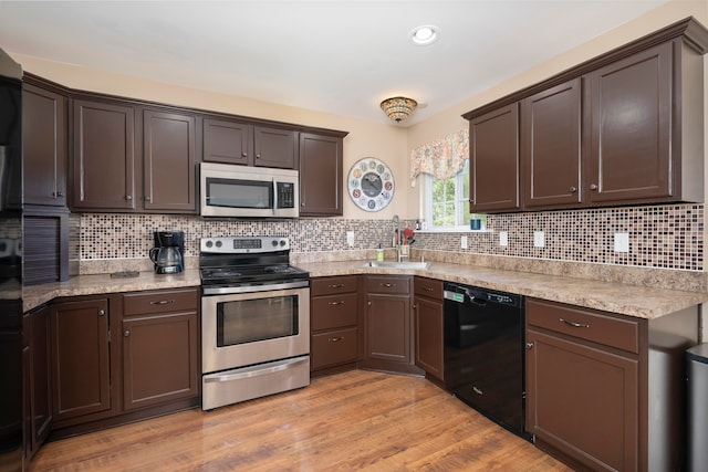 kitchen featuring decorative backsplash, appliances with stainless steel finishes, and light hardwood / wood-style flooring