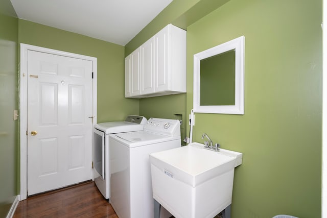 clothes washing area featuring washing machine and dryer, cabinets, sink, and dark wood-type flooring