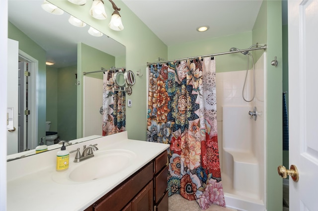 bathroom featuring a shower with shower curtain, vanity, and toilet