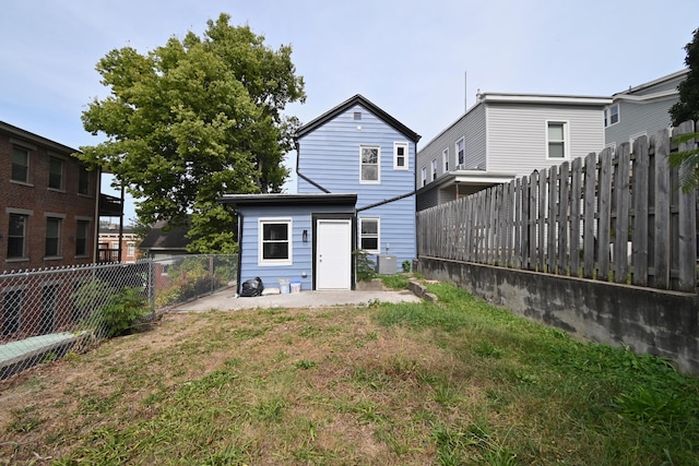 rear view of property featuring a lawn