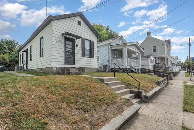 bungalow-style home with a front lawn and central AC